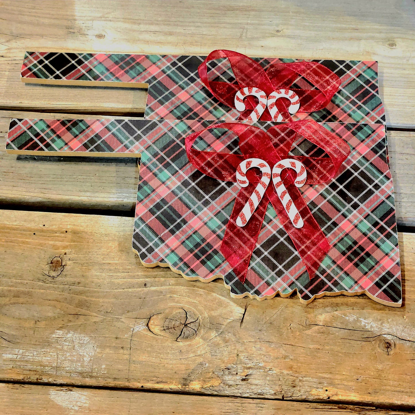 Wooden Oklahoma shape covered in plaid design with bow and candy cane accents.